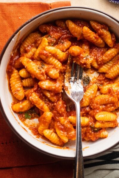Gnocchetti sardi (malloreddus) in a tomato butter sauce in a bowl set over a napkin.