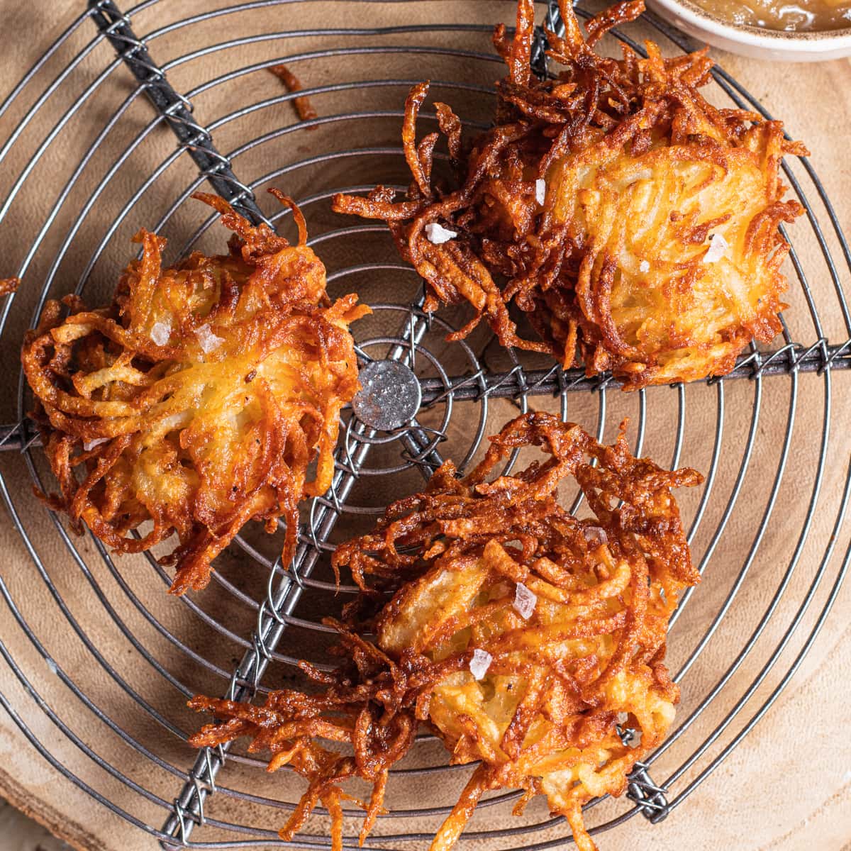 Crispy potato latkes cooling on a wire rack.
