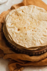 A buttered stack of chapatis on a kitchen towel.
