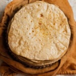 A buttered stack of chapatis on a kitchen towel.