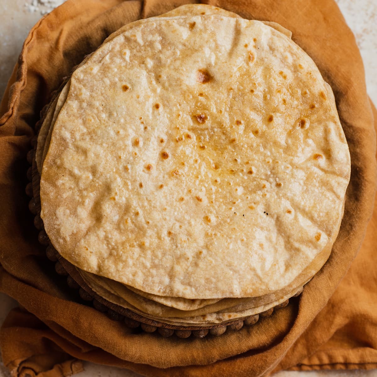 A buttered stack of chapatis on a kitchen towel.