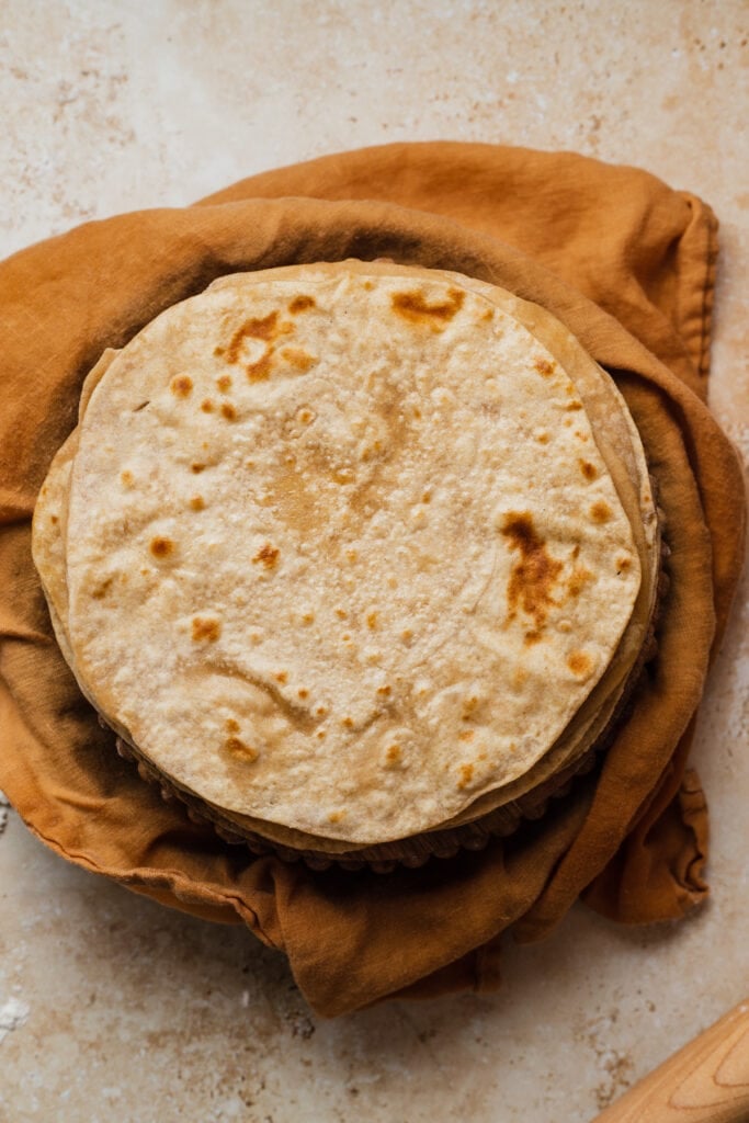 Homemade chapatis in a kitchen towel.