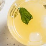 A glass of limbu sarbat with mint and cardamom