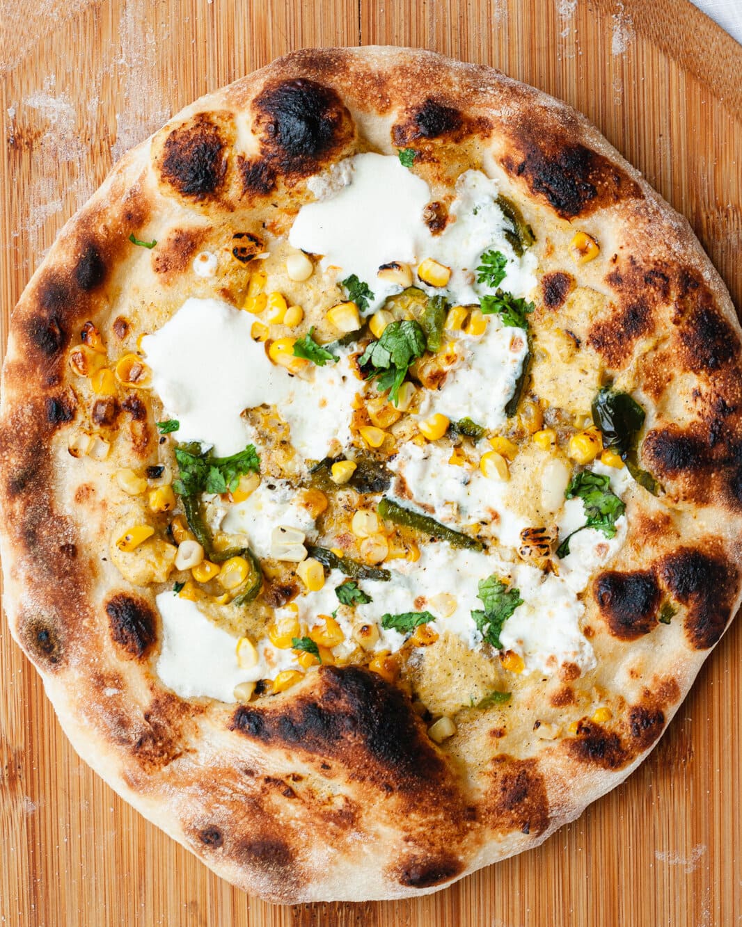 Corn pizza on a pizza peel.