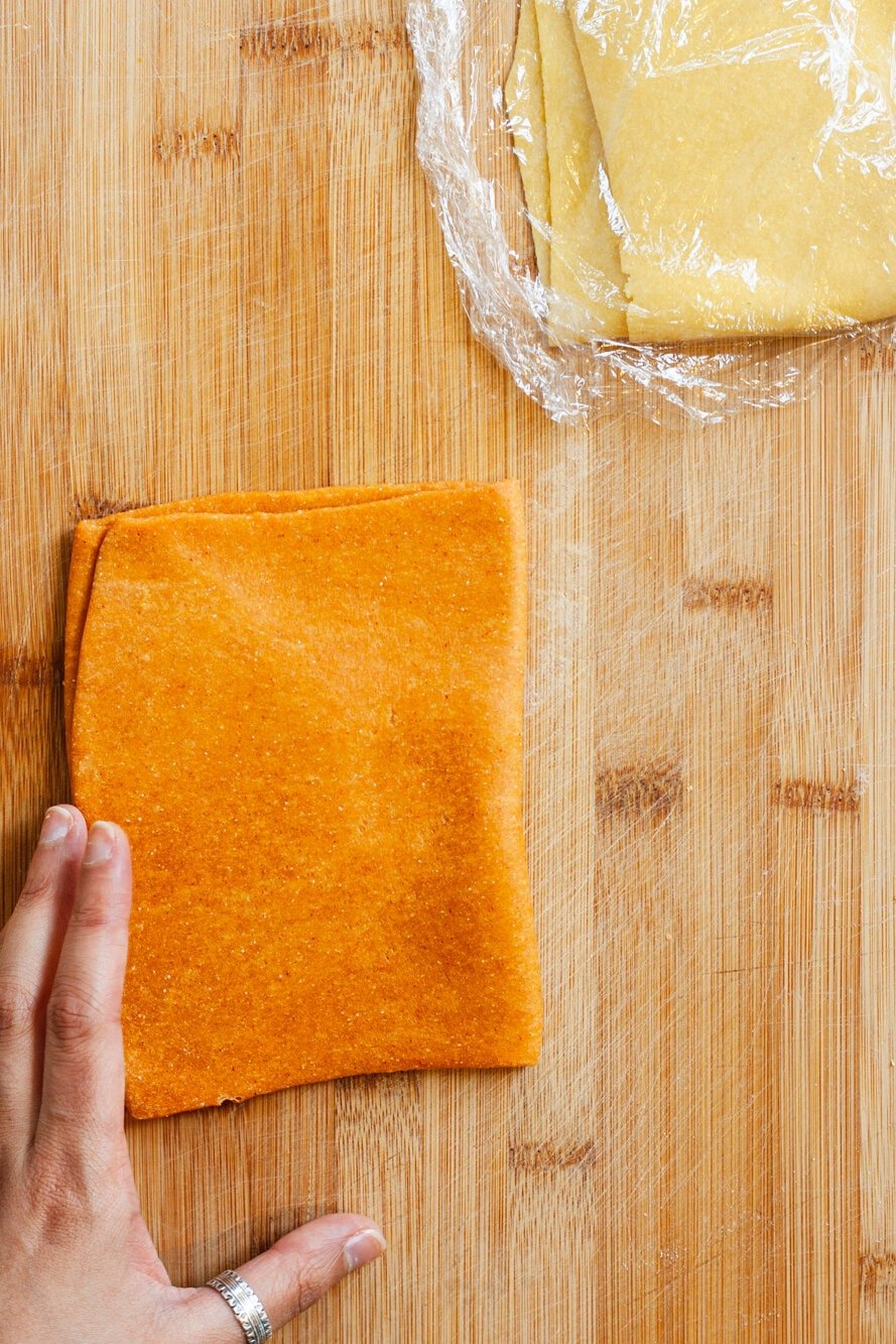 Orange dough on a cutting board.