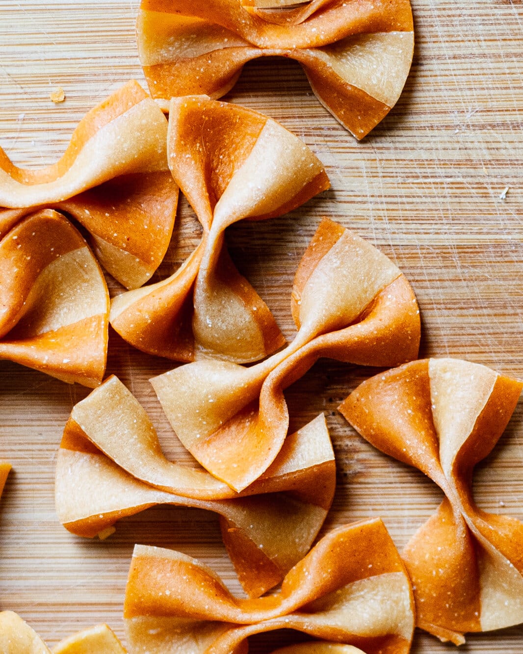Striped farfalle on a cutting board.