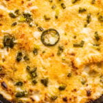 Broiled pepper jack mac and cheese with jalapenos in a cast-iron skillet.