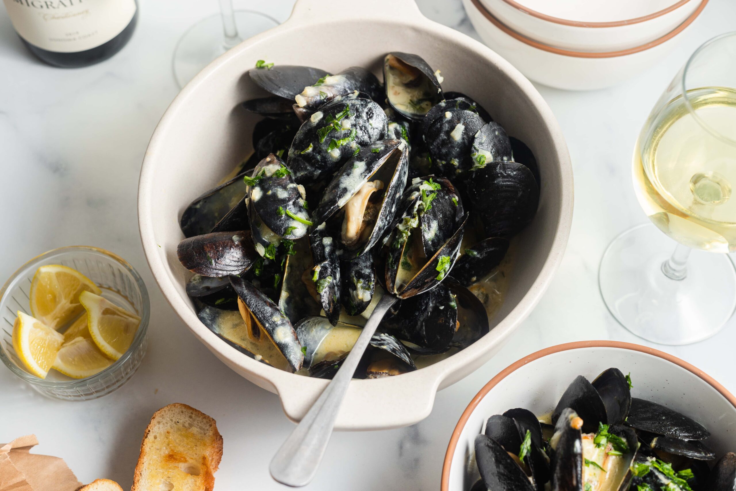 Mussels in a creamy garlic sauce with toast served in bowls