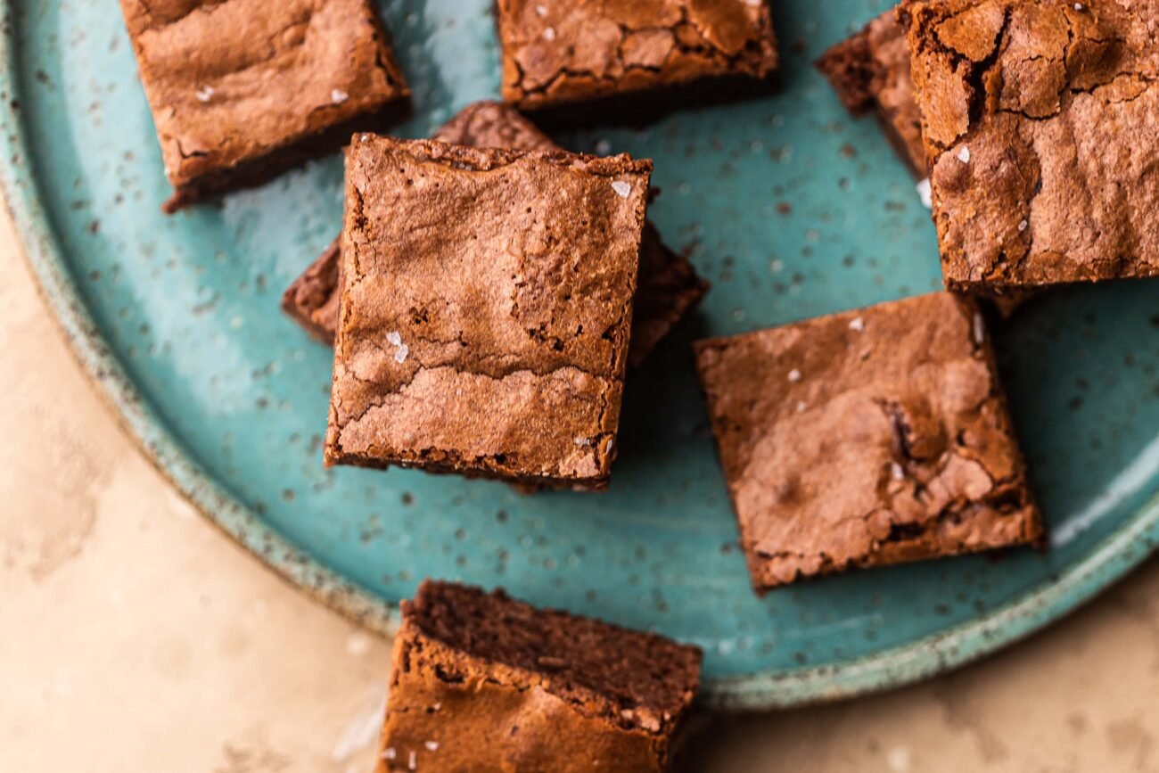 Plate of fudgy greek yogurt brownies topped with flaky sea salt.