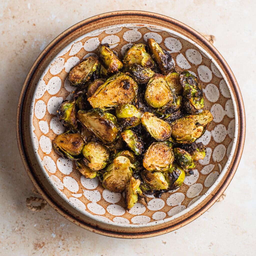 Caramelized roasted brussels sprouts with a maple balsamic glaze in a bowl.