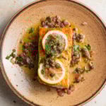 Filet of salmon meuniere in a brown butter caper sauce garnished with lemon.