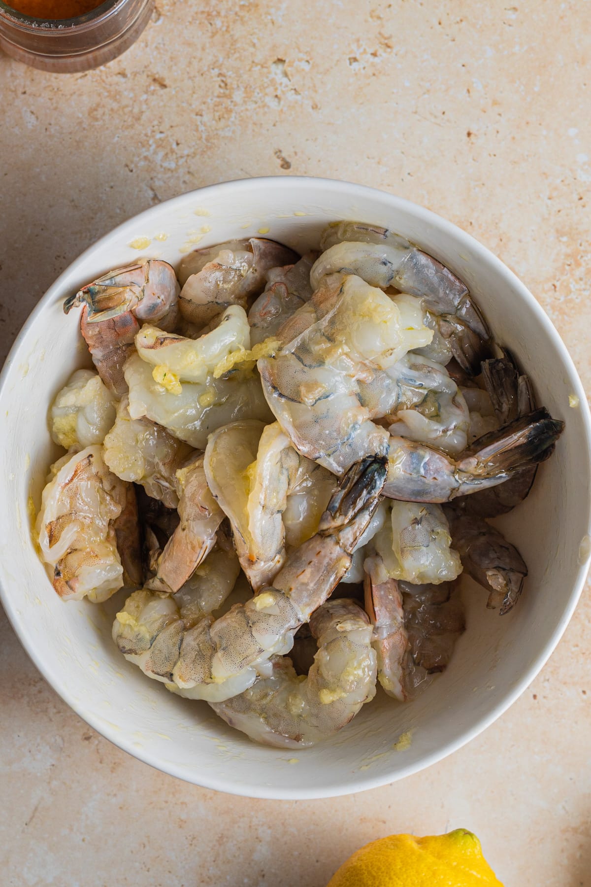Bowl of shrimp marinating with grated garlic and salt. 