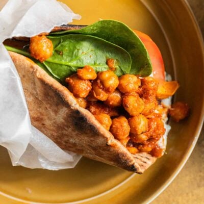 Pita wrapped up like a gyro in wax paper and stuffed with sauced chickpeas, spinach, and tomato.