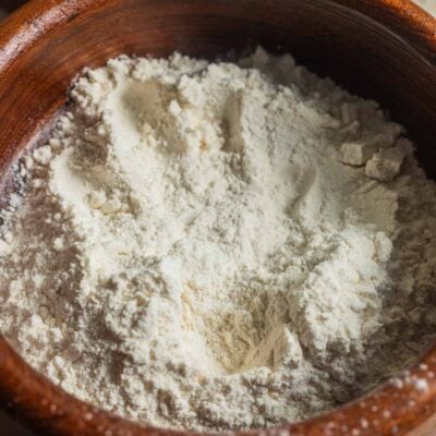 A wooden bowl filled with unsifted bread flour.