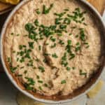 A bowl of French onion dip topped with chives.