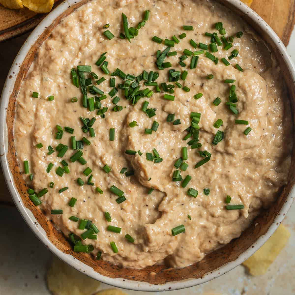A bowl of French onion dip topped with chives.