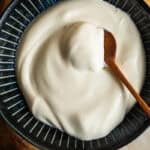 A bowl of creme fraiche with a wooden spoon in it.