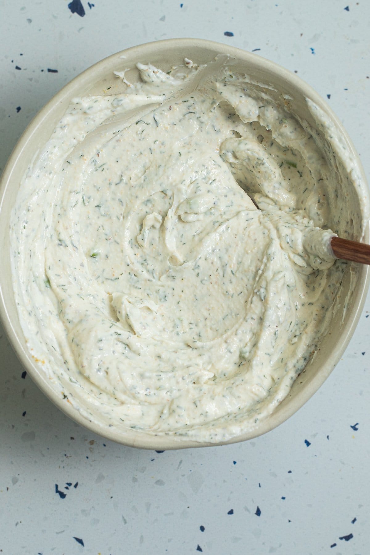 A bowl of Greek yogurt mixed with dried spices.