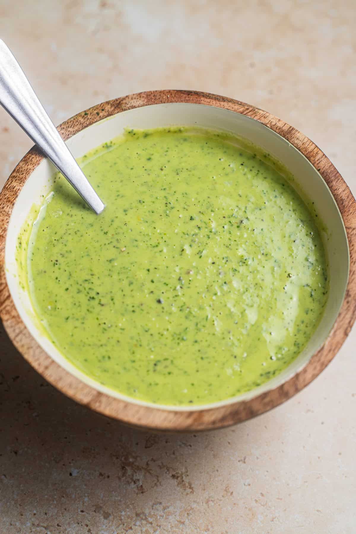 A bowl of lemon pesto with a spoon in it.