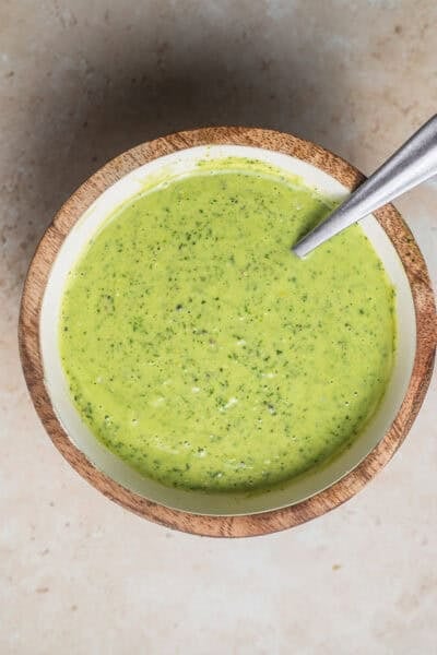 A bowl of lemon pesto with a spoon in it.
