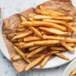 A platter of homemade fries with aioli in the background.
