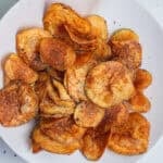 A bowl of potato chips with a black pepper coating.