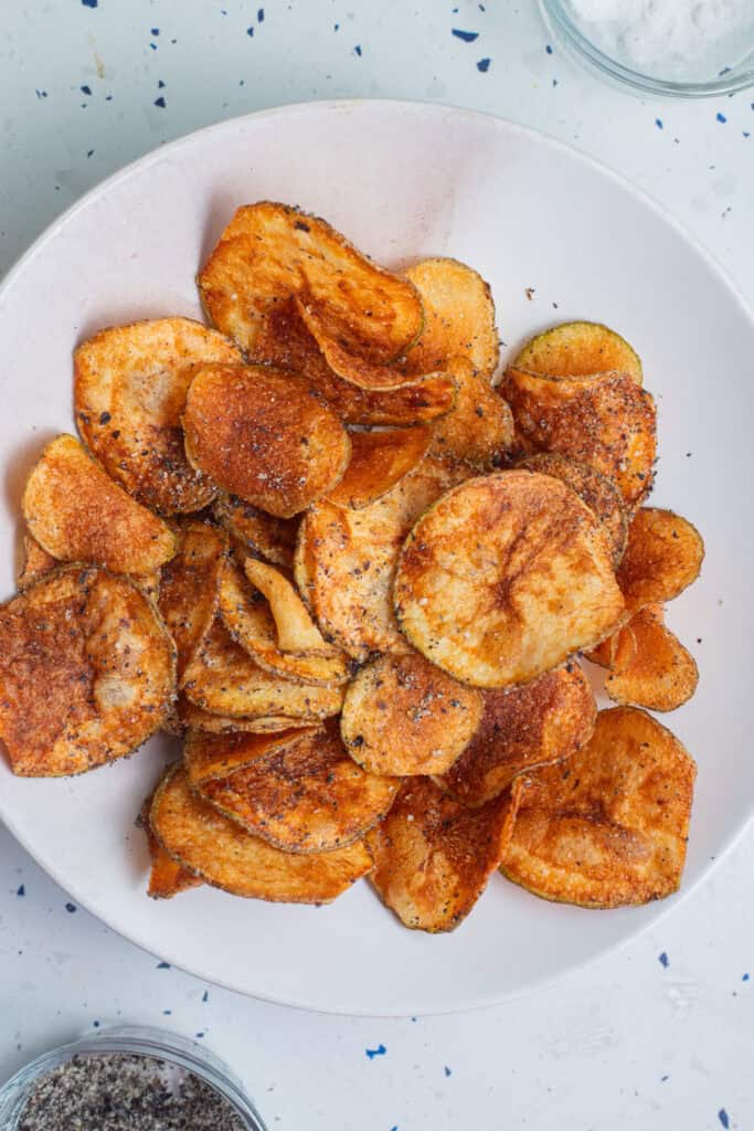 A bowl of potato chips with a black pepper coating.