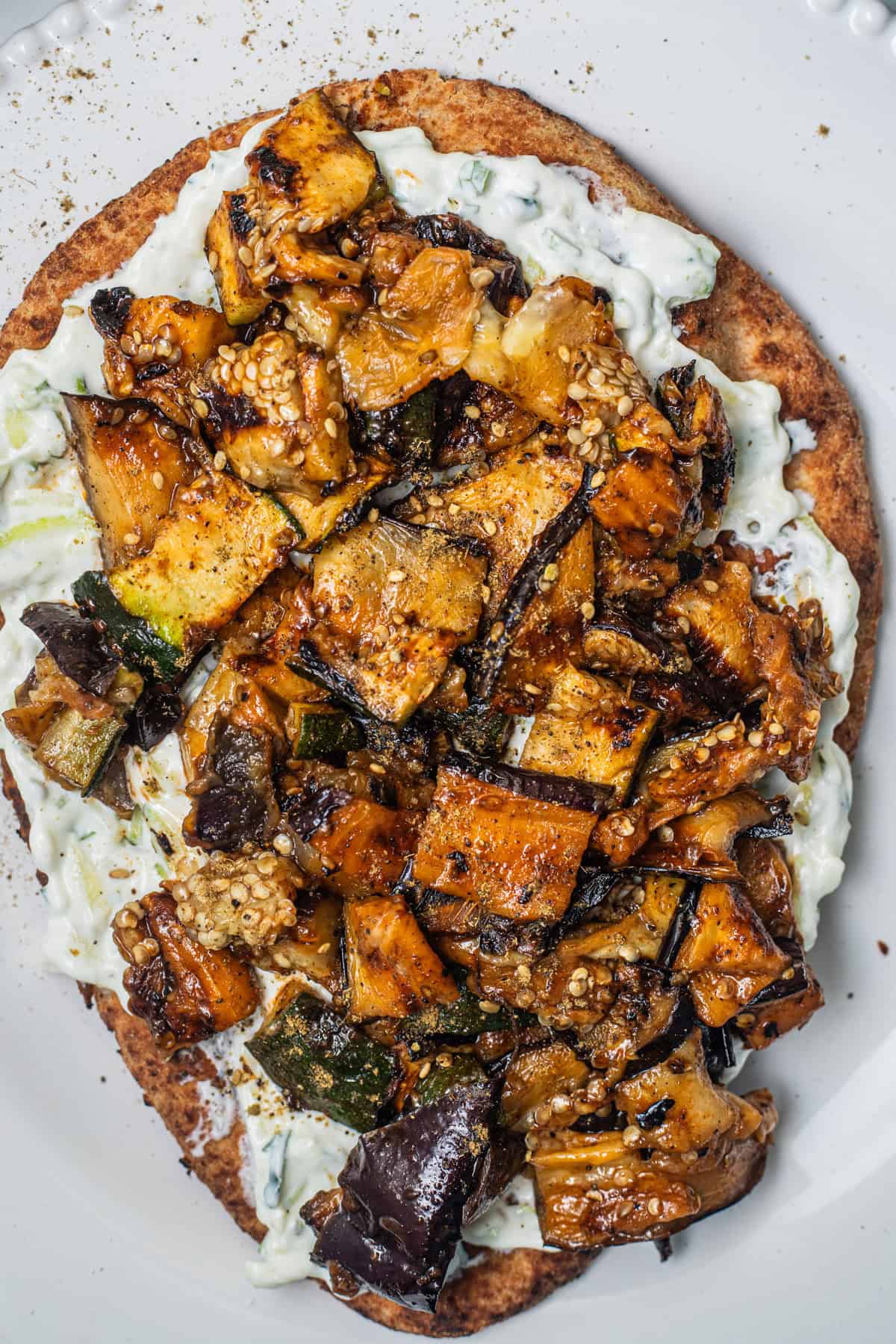 Grilled chopped vegetables on a bed of yogurt on a whole-wheat naan.
