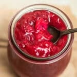 A jar of rhubarb jam with a spoon in it.